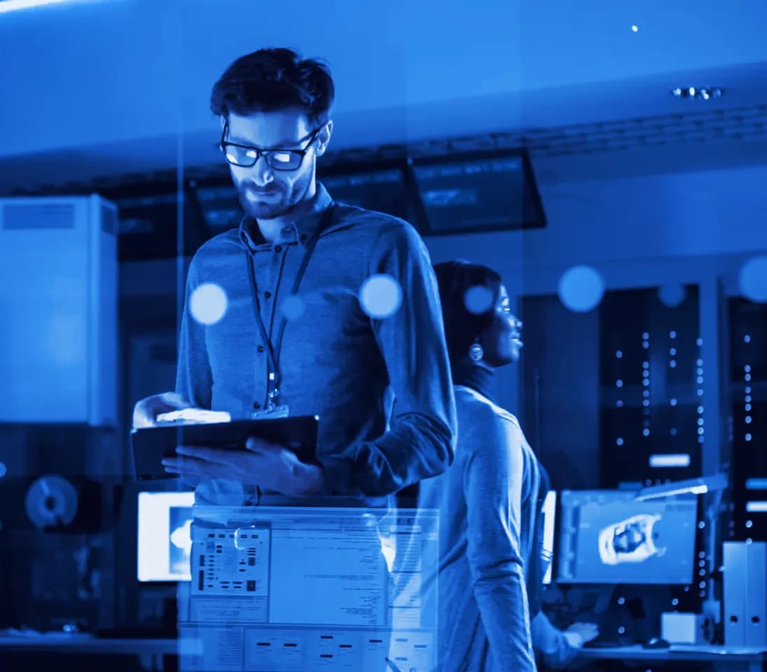 Engineer reviewing server status on a tablet in a server room